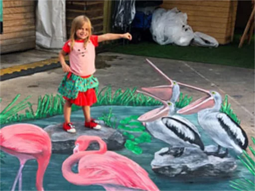 Child posing on Everglades pond with pelicans and flamingos 3D chalk art