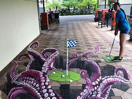 Posing with golf putting green with octopus tentacles 3D chalk art