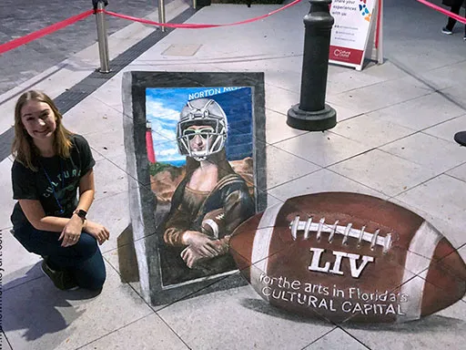 Posing with 3D chalk art Mona Lisa in a football helmet chalk art