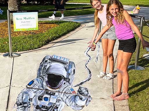 Posing with 3D chalk image of floating astronaut
