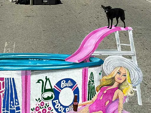 Dog posing with painted image of Ken and Barbie dolls in Pool Party set