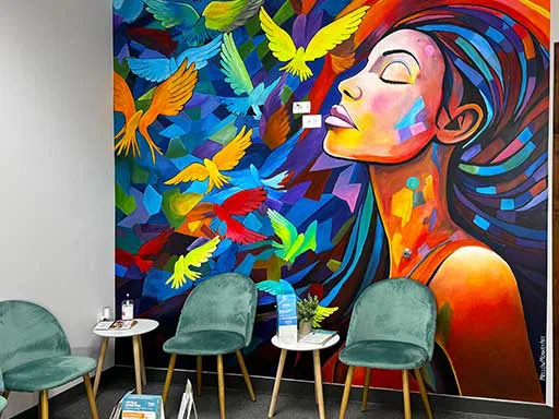 Angle view of colorful abstract wall mural with woman's profile and birds