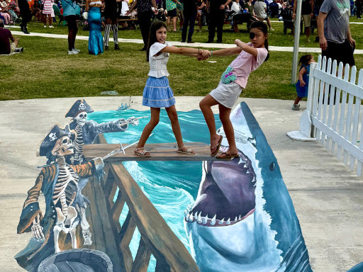 Posing with 3D painted vinyl image of a ghost ship with skeletons pointing toward the plank and a leaping shark with open mouth.