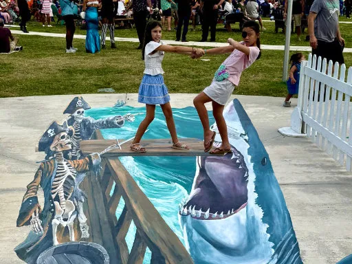 Posing with 3D painted vinyl image of a ghost ship with skeletons pointing toward the plank and a leaping shark with open mouth.
