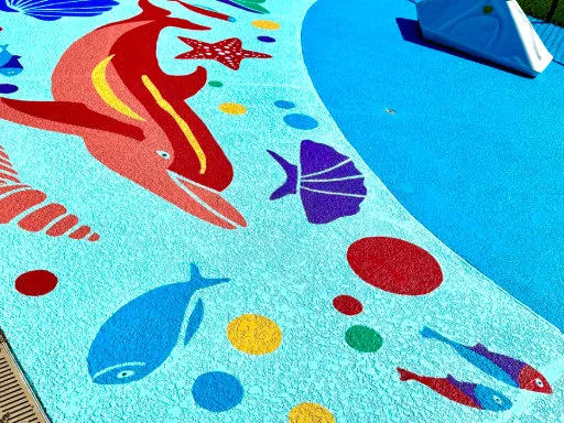 Colorful sea life mural on the ground of a childrens splash pad water playground.