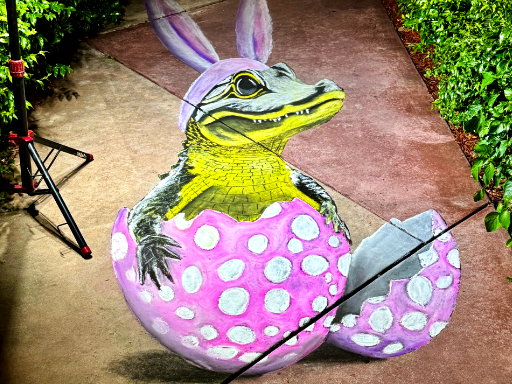 3D chalk art of a Florida Alligator dressed up in bunny ears, sitting in an Easter egg.