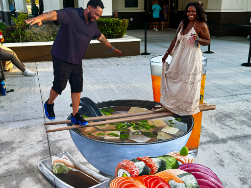 Posing with 3D chalk and painted art of sushi and miso soup with a beer.