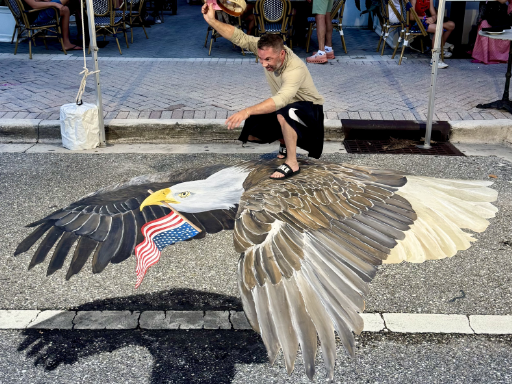 Posing with 3D chalk and painted art of American eagle flying for 4th of July celebration.