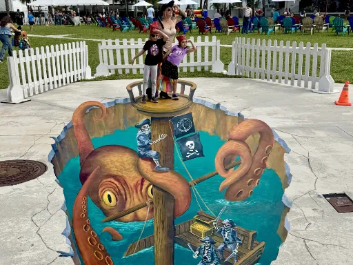 Posing with 3D painted art of sinking pirate ship with skeleton pirates being attacked by a kraken.