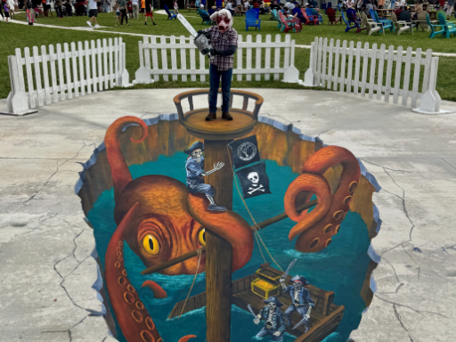 Posing with 3D painted art of sinking pirate ship with skeleton pirates being attacked by a kraken.