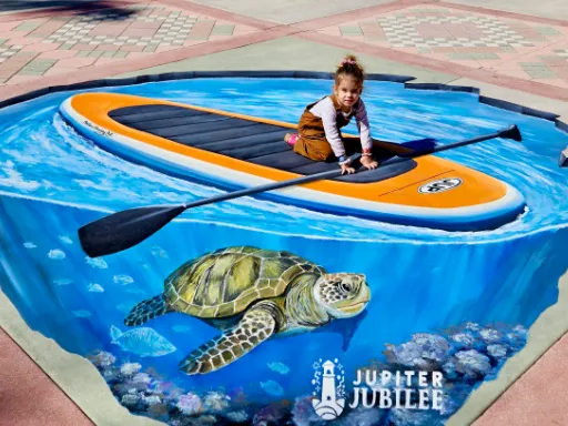Posing with 3D painted art of paddleboard with sea turtle for Jupiter Jubilee.