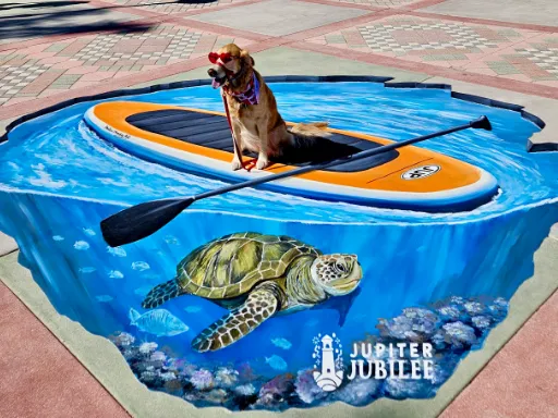 Posing with 3D painted art of paddleboard with sea turtle for Jupiter Jubilee.