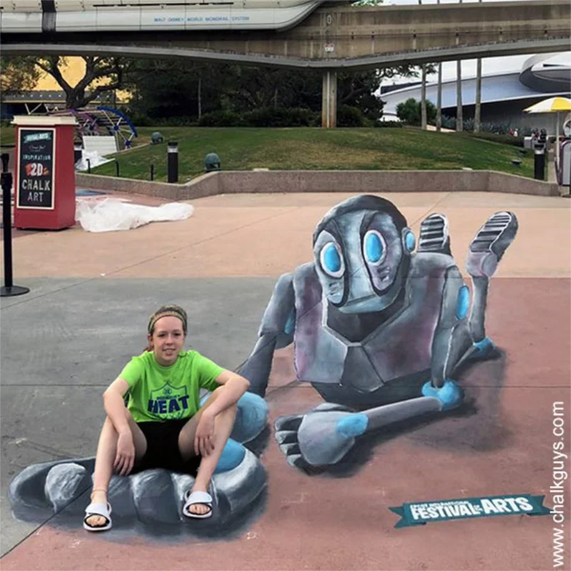 Girl posing with Epcot Giant Robot 3D chalk art.