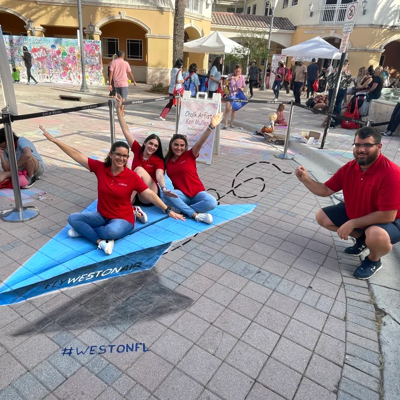 Posing on 3D chalk art of paper airplane.